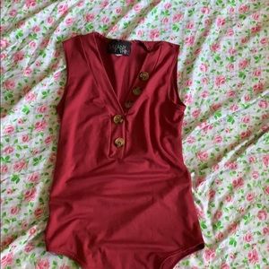 A burgundy button body suit